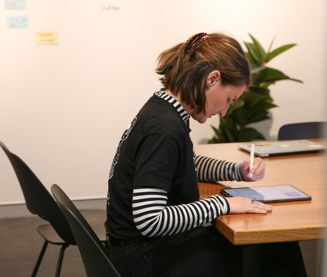 A person takes notes with a tablet.