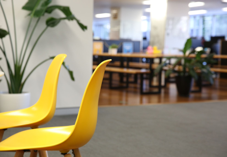Two yellow meeting chairs in an office.
