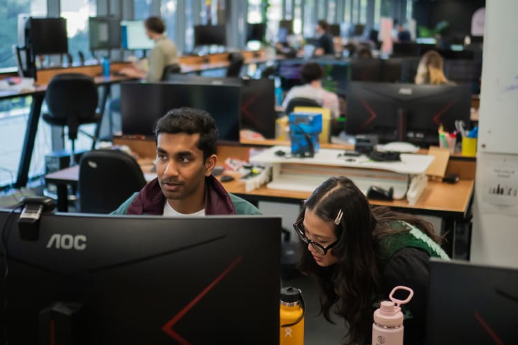 A photo of a man and a woman working on a computer