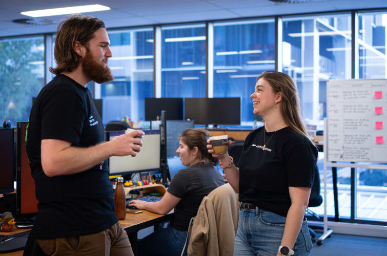 a man and a woman talking in front of computers