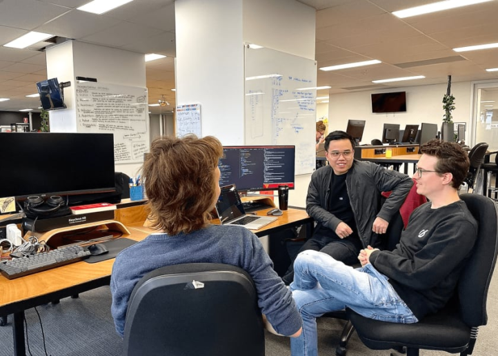 Three workingmouse employees sitting around a computer