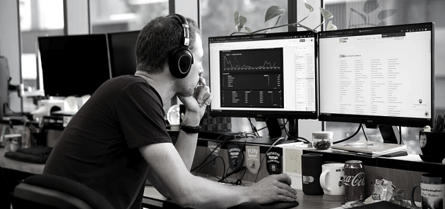 A balck and white photo of a man working at a computer