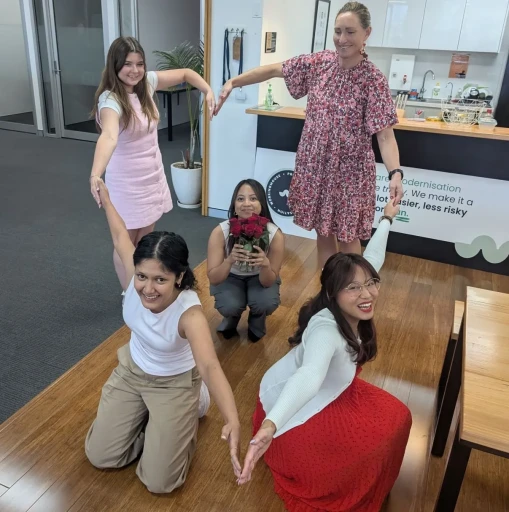 The WokringMouse women show their low by making the shape of a heart and holding flowers.